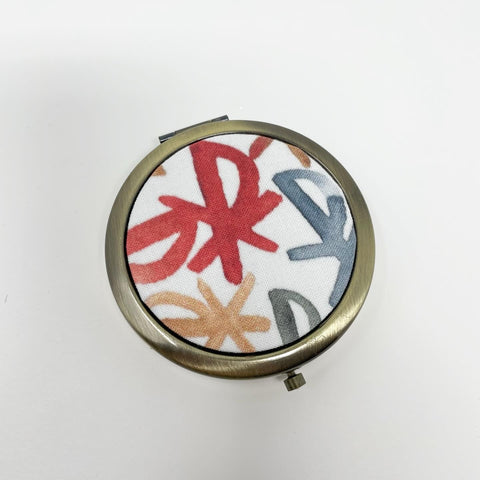 White background with multi-color watercolor Chi Rho symbols; 3 compartment antique bronze pill box