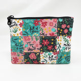 Quilted zipper pouch; Bright and cheery floral background with the words of the Hail Mary interspersed throughout with white, pink, turquoise, and black backgrounds; black lining; black zipper
