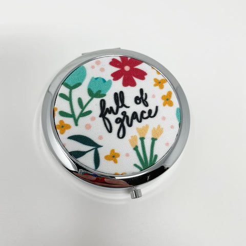 Bright and cheery white floral background with the words of the Hail Mary interspersed throughout; 1 compartment silver pill box