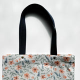 Unlined tote bag measuring approximately 13” wide x 15” tall. Exterior fabric features beautiful watercolor floral design with the words "made worthy" and "dearly beloved" interspersed throughout. Navy cotton webbing straps.