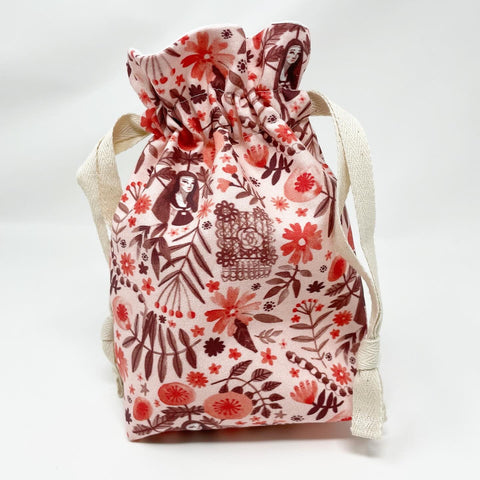 St. Thérèse of Lisieux drawstring bag; main fabric exterior is Light pink with dark maroon and coral floral print and image of St. Thérèse; white lining