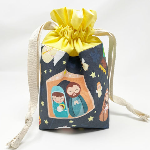 Nativity drawstring pouch; main exterior has images of the Nativity; yellow accent; white lining